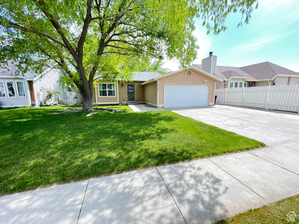 Ranch-style house with a garage, concrete driveway, and a chimney