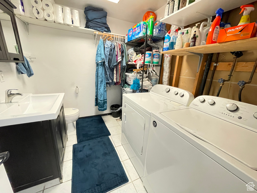 Laundry room with washer and dryer and light tile patterned floors