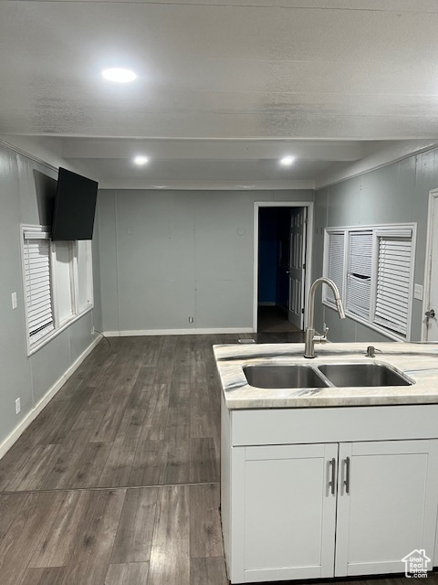 Kitchen with a sink, dark wood-style flooring, white cabinetry, light countertops, and recessed lighting