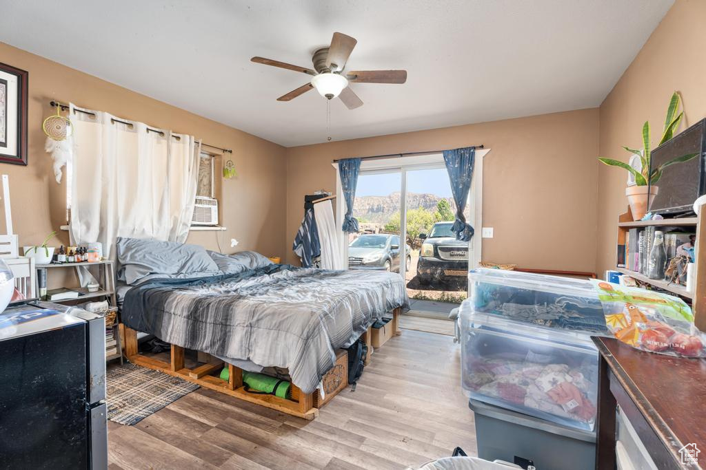Bedroom with access to outside, light wood finished floors, a ceiling fan, and cooling unit