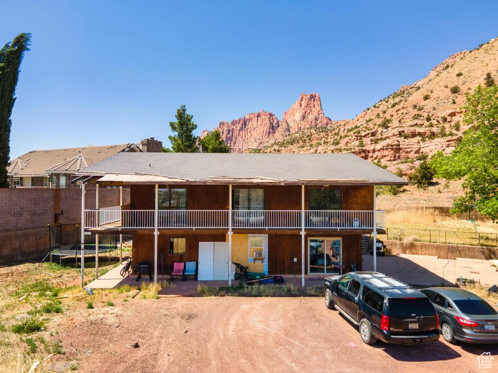 Rear view of house featuring a trampoline and a mountain view