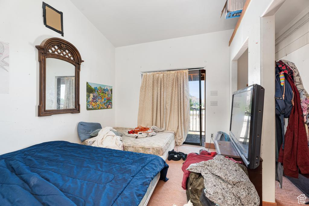 Bedroom featuring carpet, access to outside, and vaulted ceiling