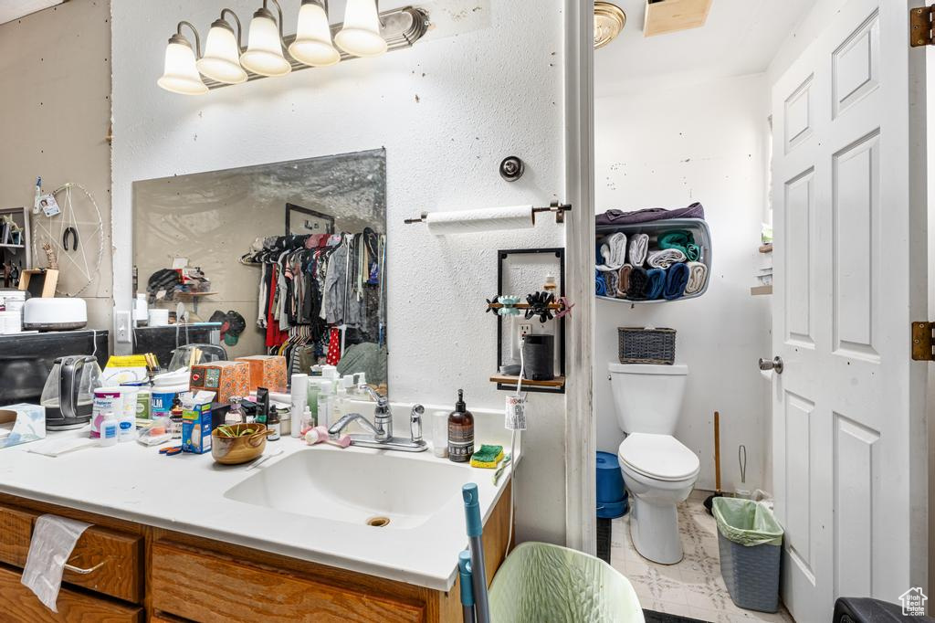 Bathroom featuring vanity, toilet, and a closet