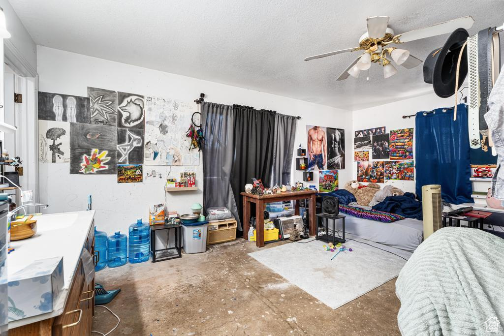Bedroom with concrete floors, a sink, and a ceiling fan