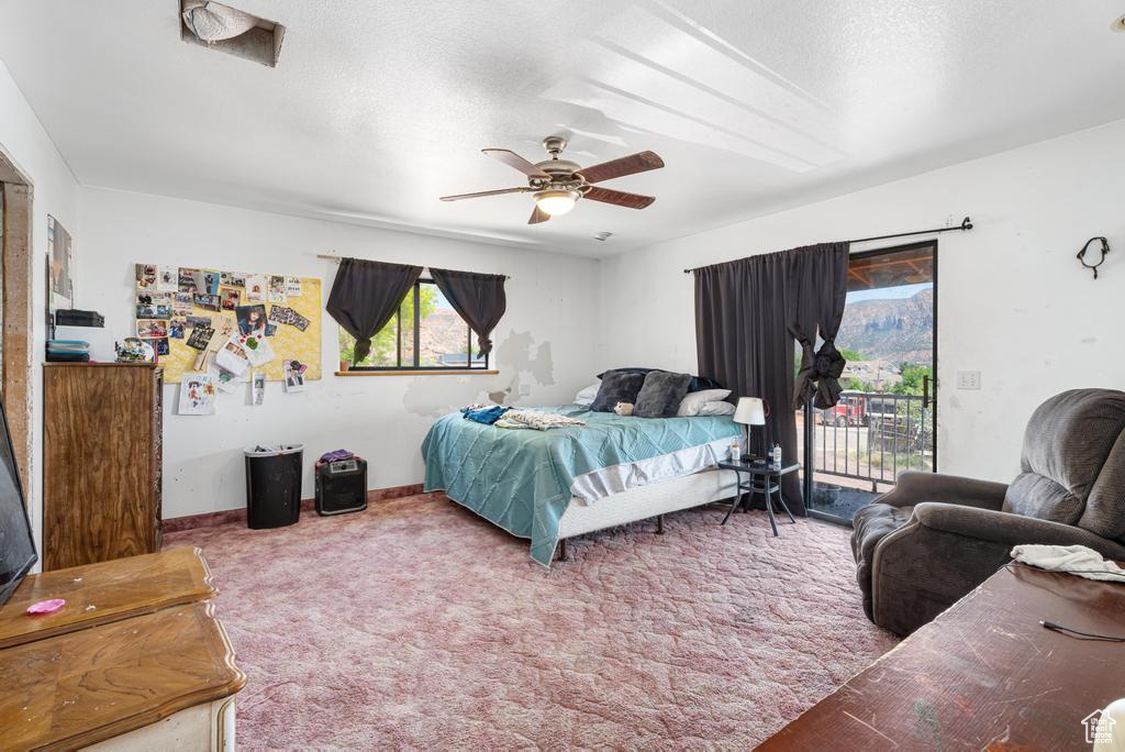 Carpeted bedroom with access to outside and ceiling fan