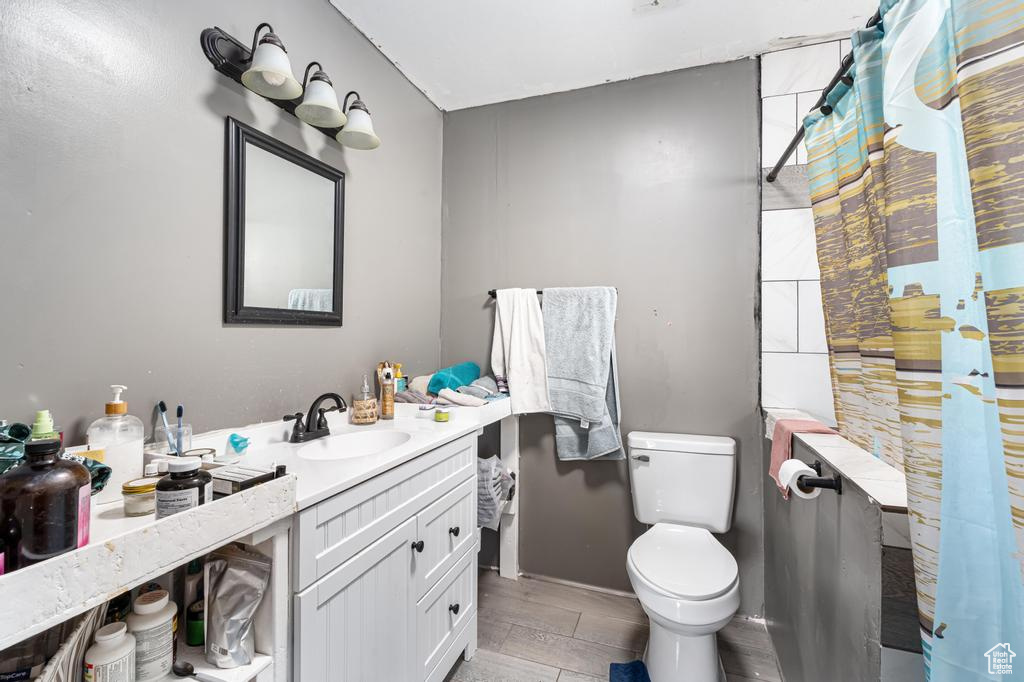 Full bath featuring toilet, vanity, and a shower with curtain