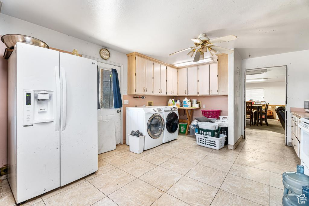 Washroom with cabinet space, washing machine and clothes dryer, a ceiling fan, and light tile patterned floors
