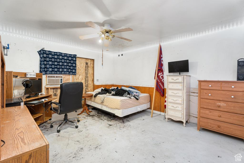 Bedroom featuring concrete floors, a desk, cooling unit, and ceiling fan