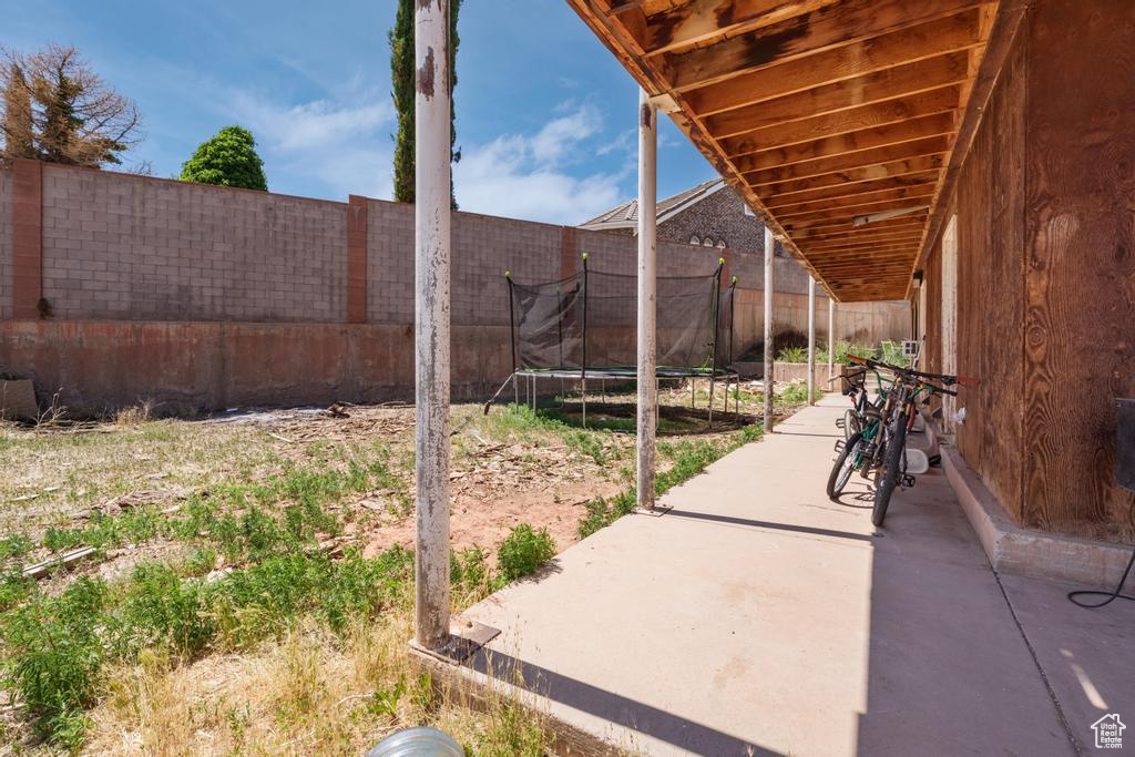 Fenced backyard with a patio area and a trampoline