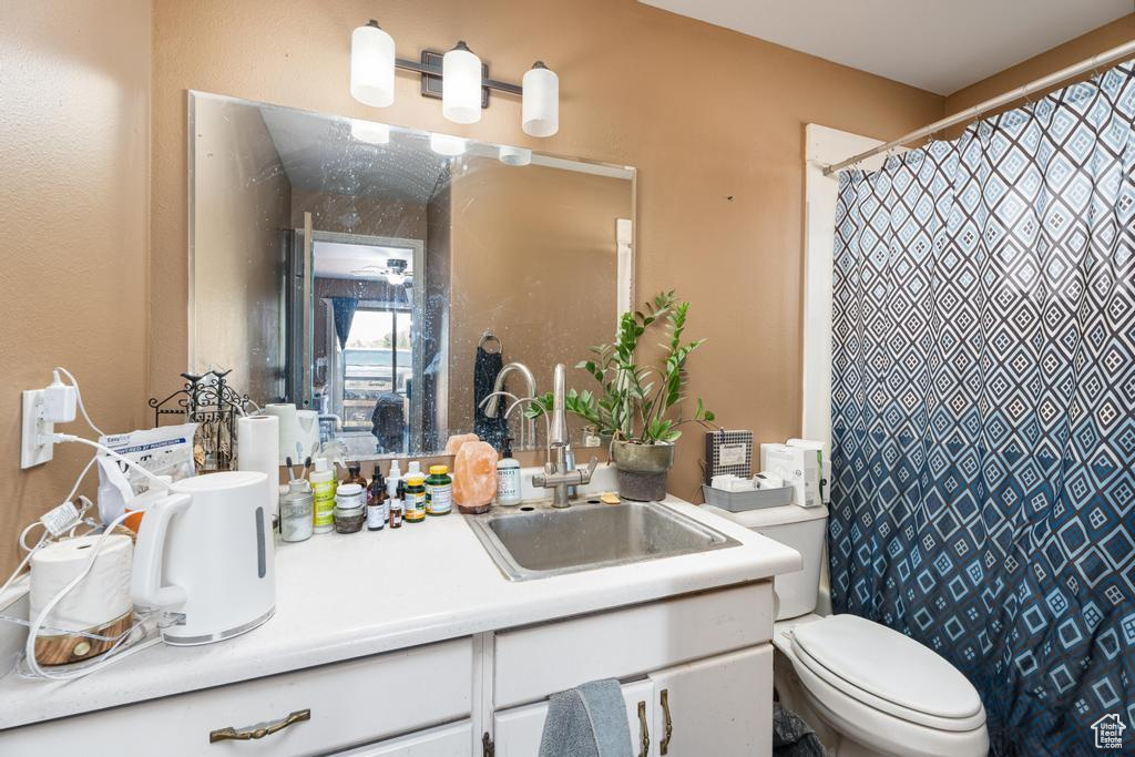 Full bath featuring vanity, toilet, and a shower with shower curtain