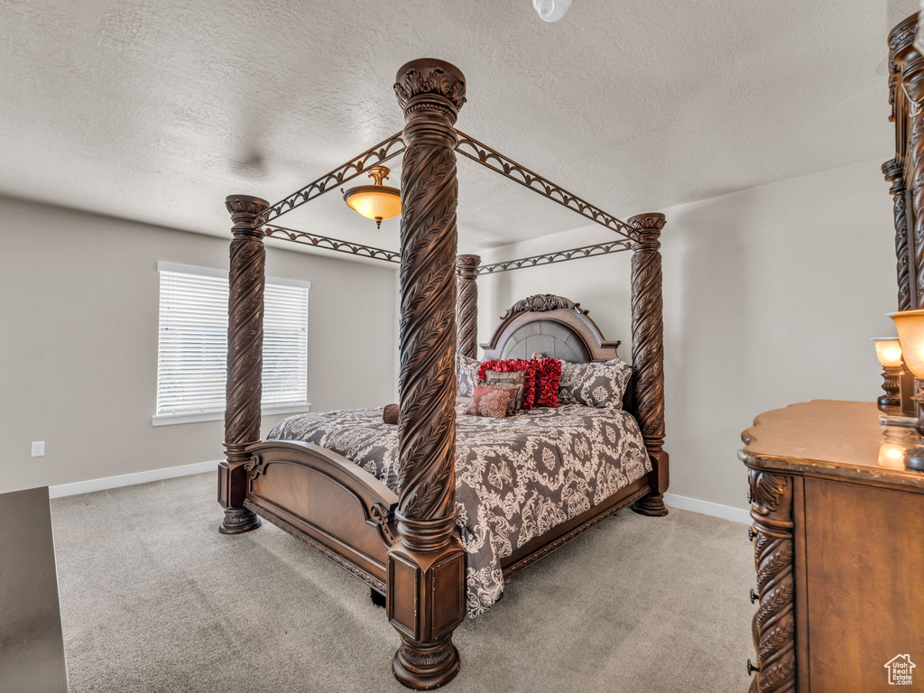 Carpeted bedroom with a textured ceiling and baseboards