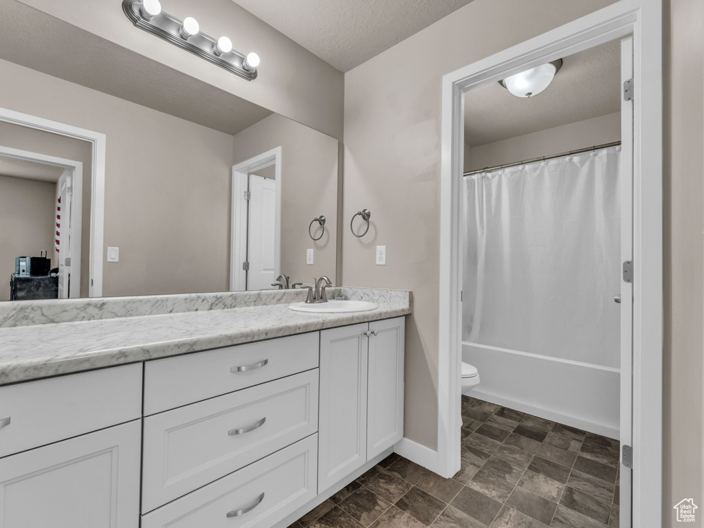 Bathroom featuring vanity, toilet, baseboards, and shower / bathtub combination with curtain