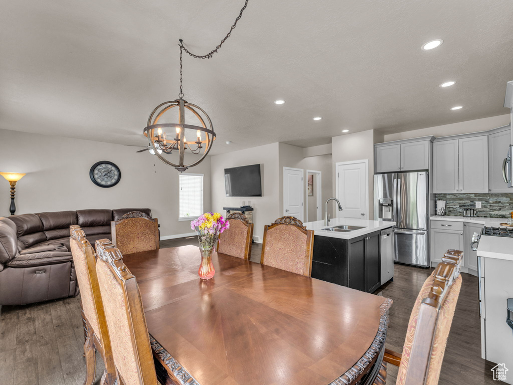 Dining room with a chandelier, recessed lighting, and dark wood-type flooring