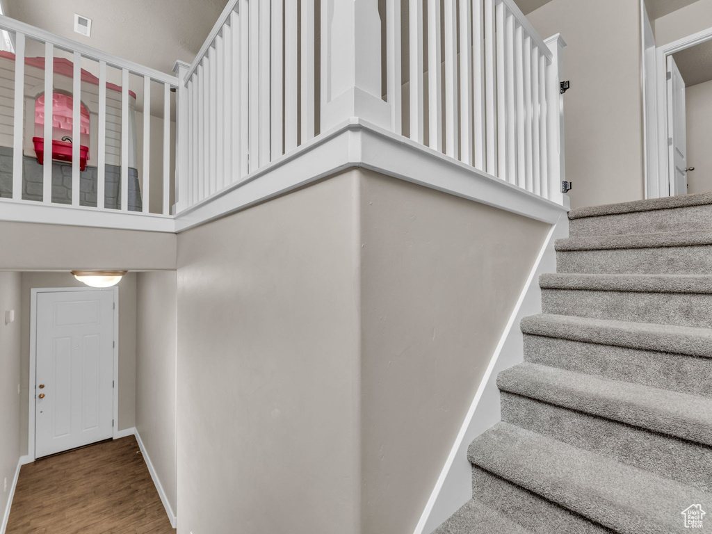 Stairway with wood finished floors and baseboards