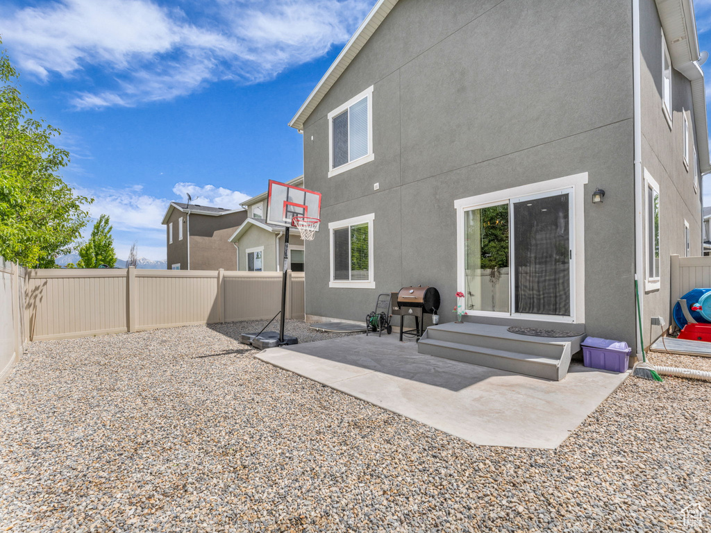 Rear view of property featuring a fenced backyard, stucco siding, and a patio area