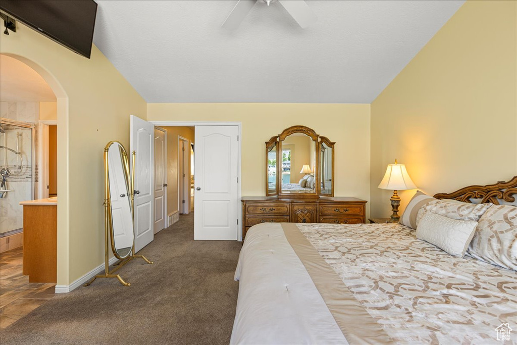 Bedroom featuring arched walkways, carpet floors, baseboards, and a ceiling fan