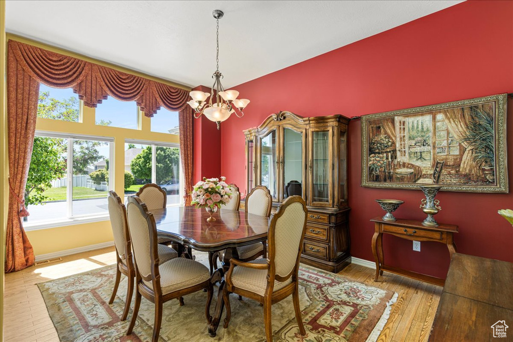 Dining room featuring a chandelier, wood finished floors, and baseboards