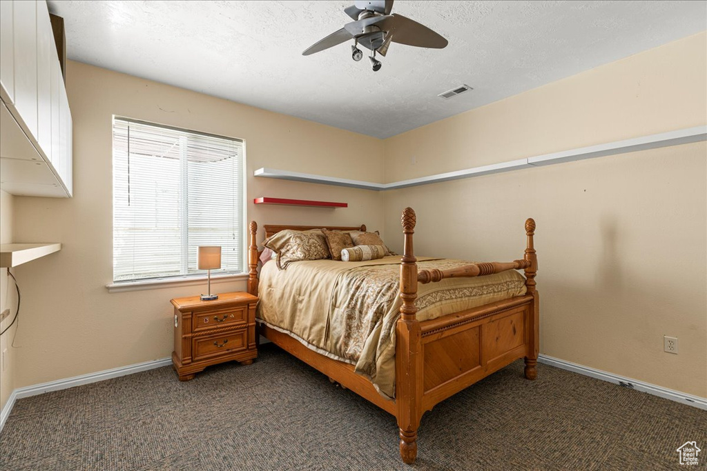 Carpeted bedroom featuring baseboards and ceiling fan
