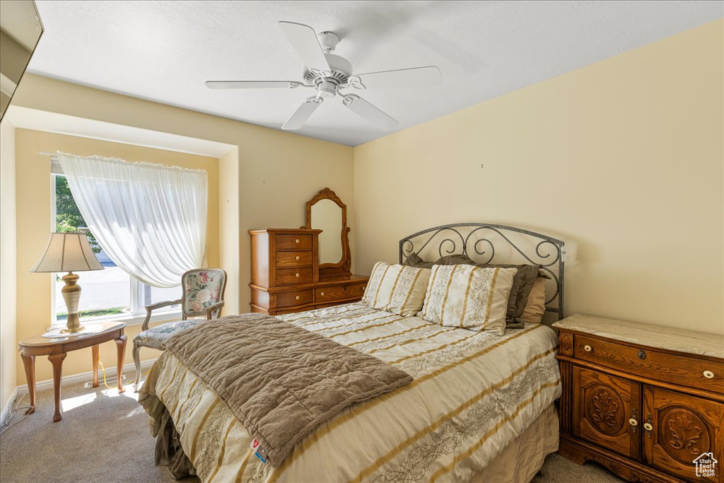 Carpeted bedroom featuring baseboards and ceiling fan
