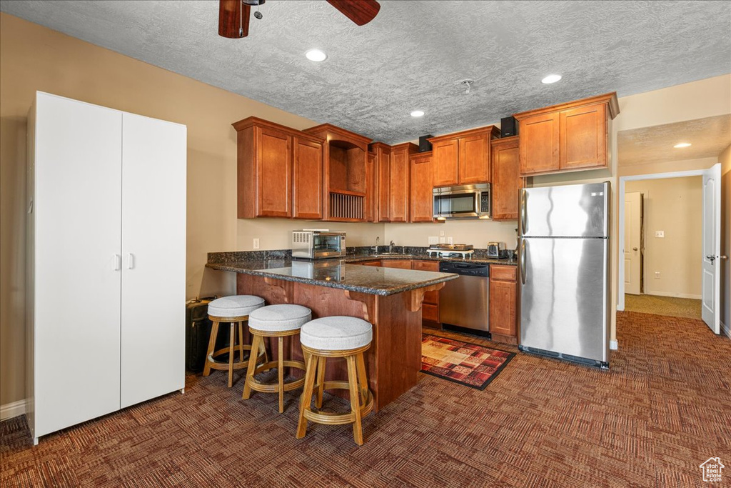 Kitchen with stainless steel appliances, dark carpet, open shelves, a peninsula, and recessed lighting