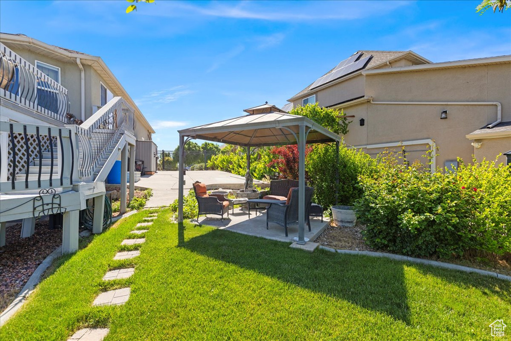 View of grassy yard featuring a gazebo, an outdoor living space, and a patio area
