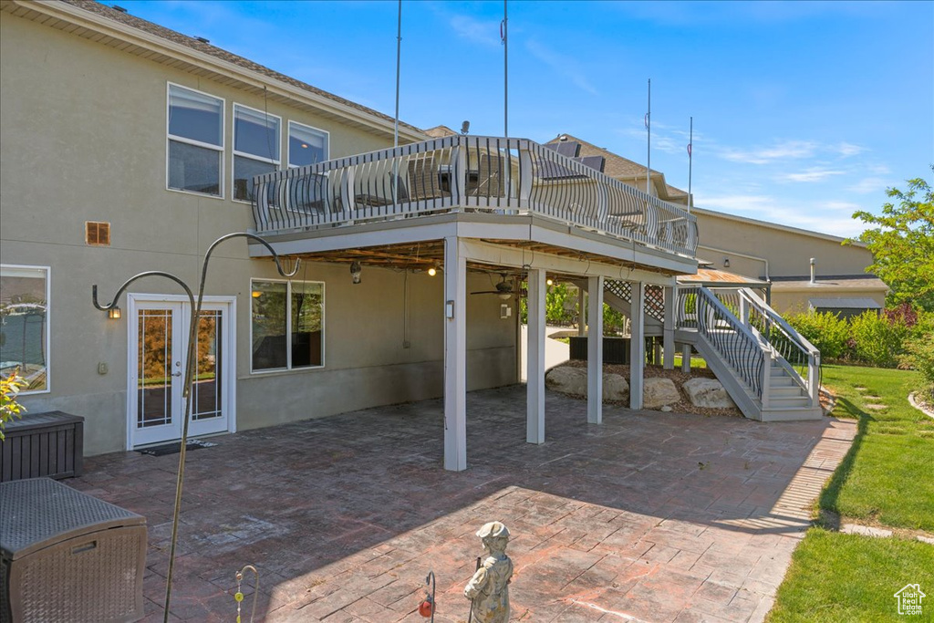 Back of property featuring a patio, a wooden deck, and stucco siding
