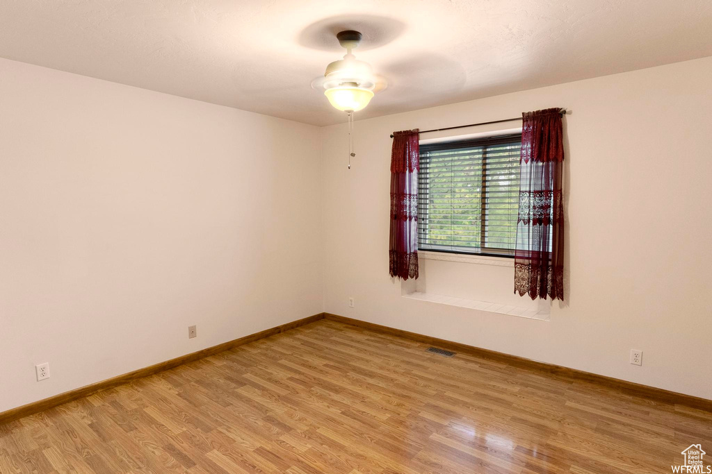 Empty room with light wood-style floors and baseboards