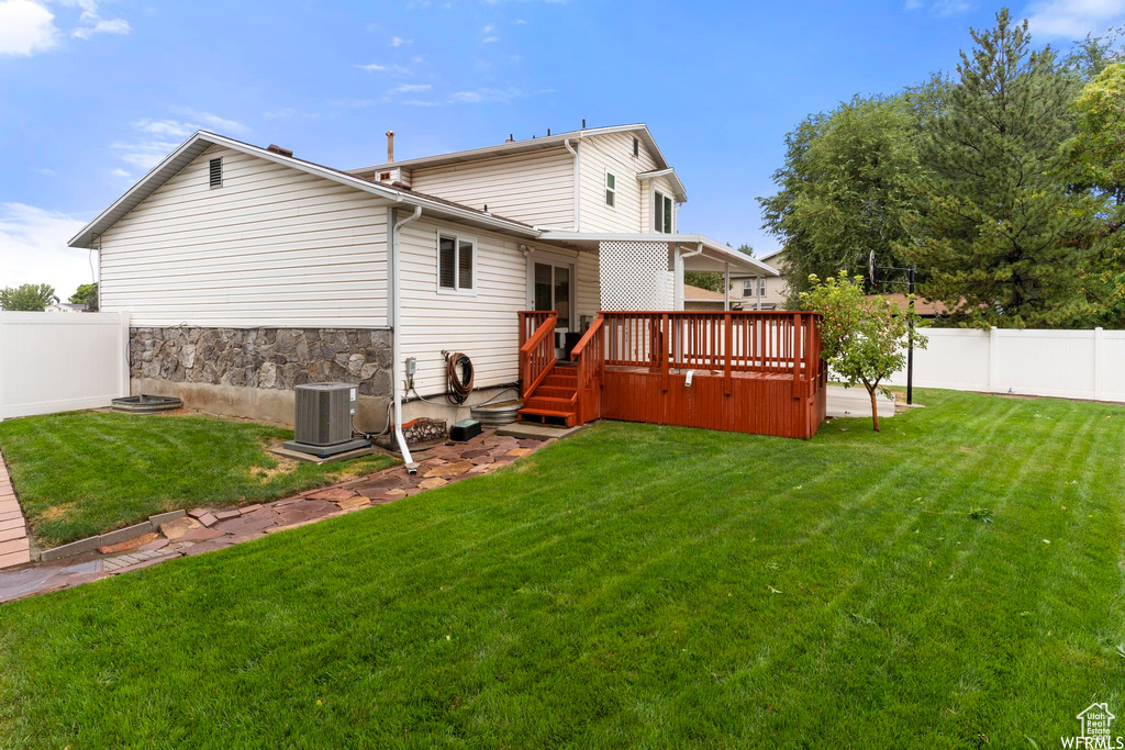 Back of house with a deck and central air condition unit