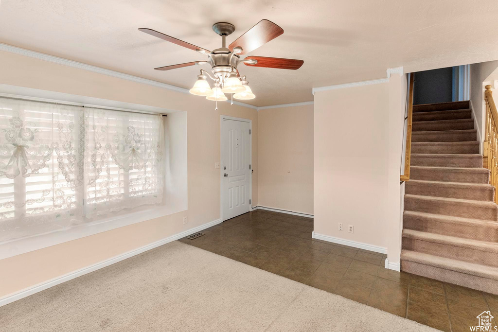 Entryway featuring stairway, ceiling fan, ornamental molding, baseboards, and tile patterned floors