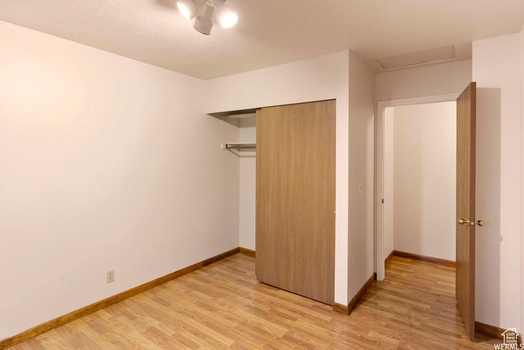 Unfurnished bedroom featuring light wood-type flooring, baseboards, a closet, and ceiling fan