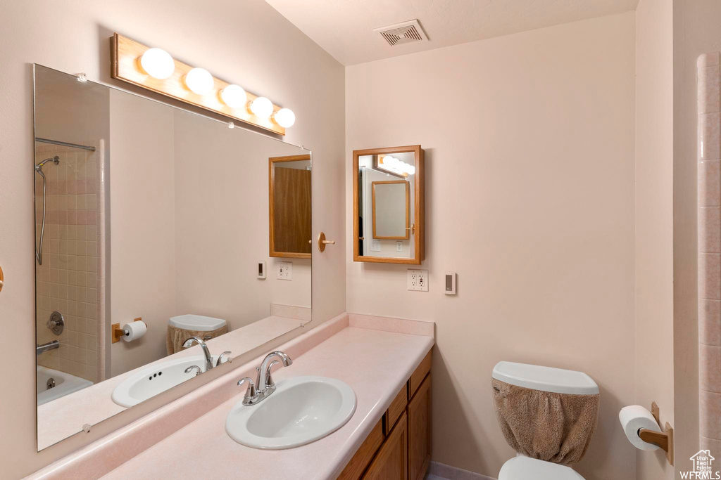 Full bathroom featuring toilet, vanity, and shower / bathtub combination