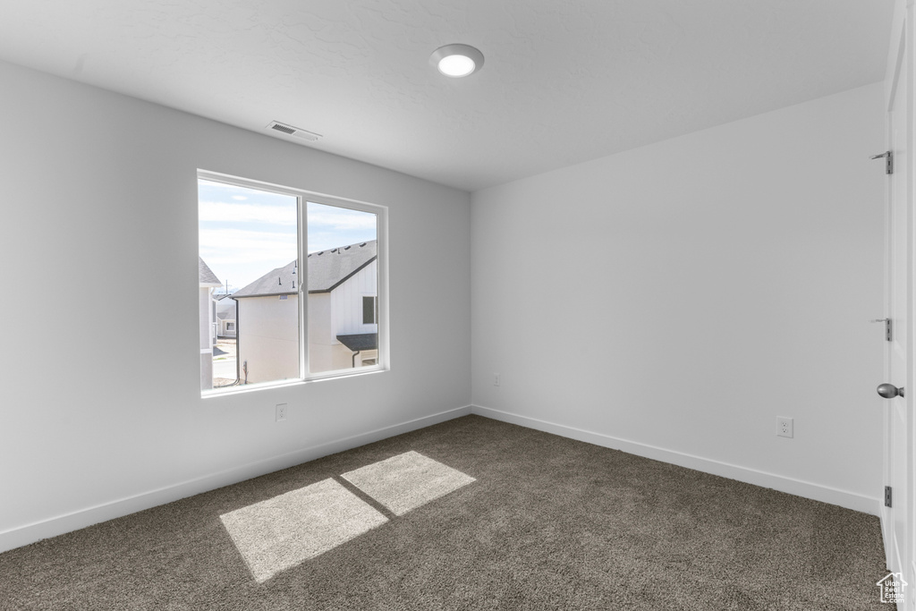 Empty room with carpet flooring and baseboards