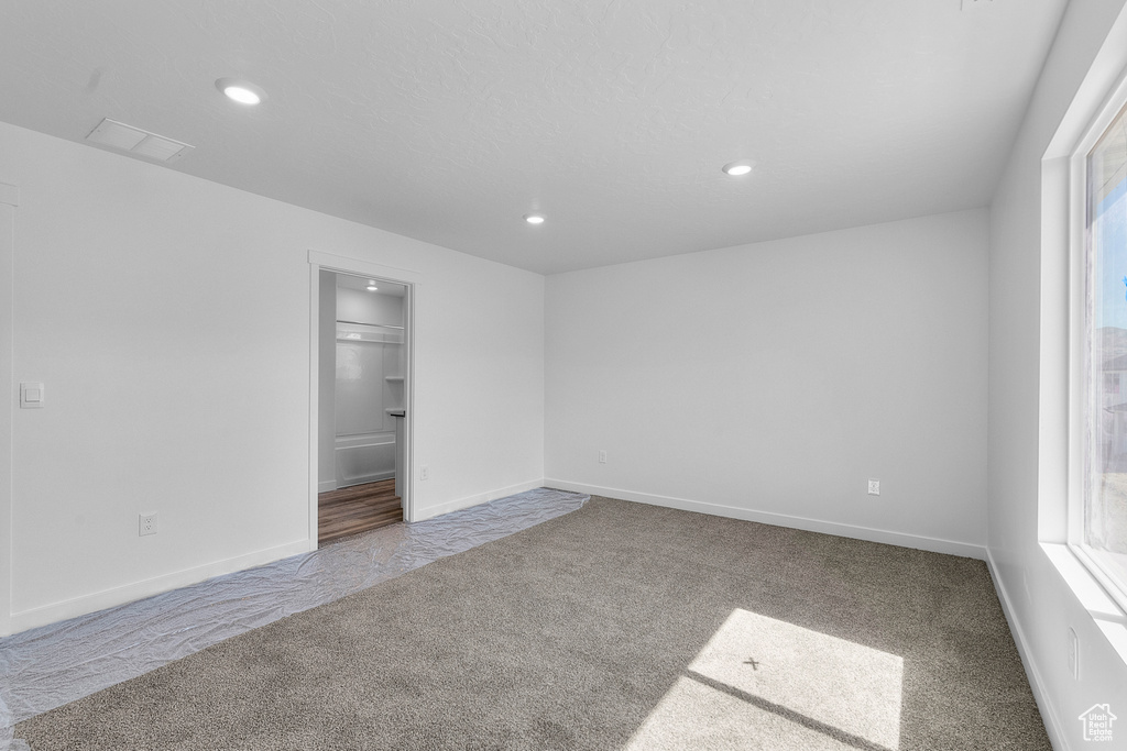 Carpeted empty room featuring recessed lighting and baseboards