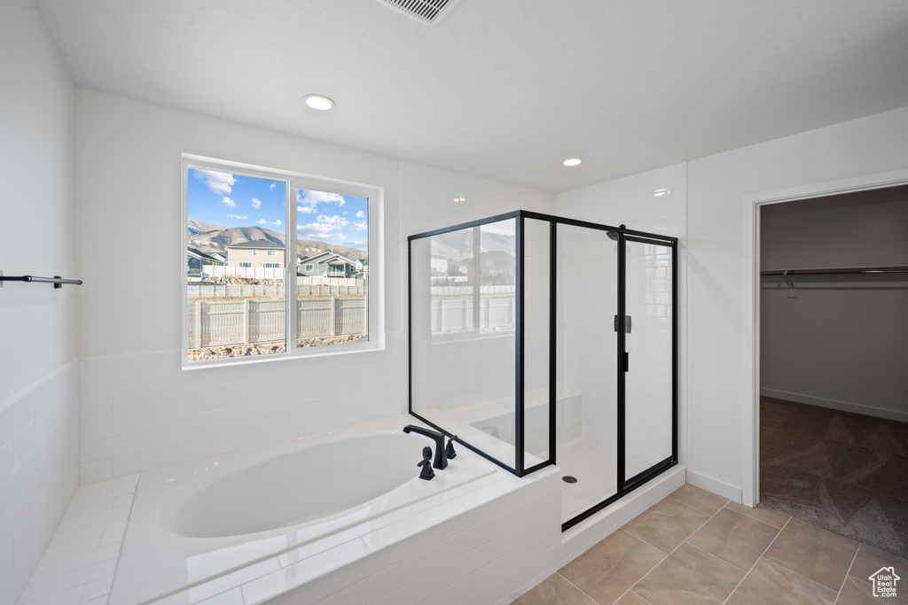 Bathroom with a garden tub, a shower stall, a spacious closet, and recessed lighting