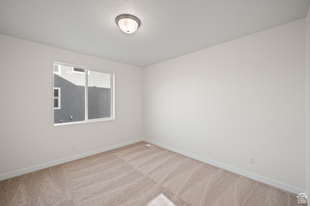 Carpeted spare room with baseboards