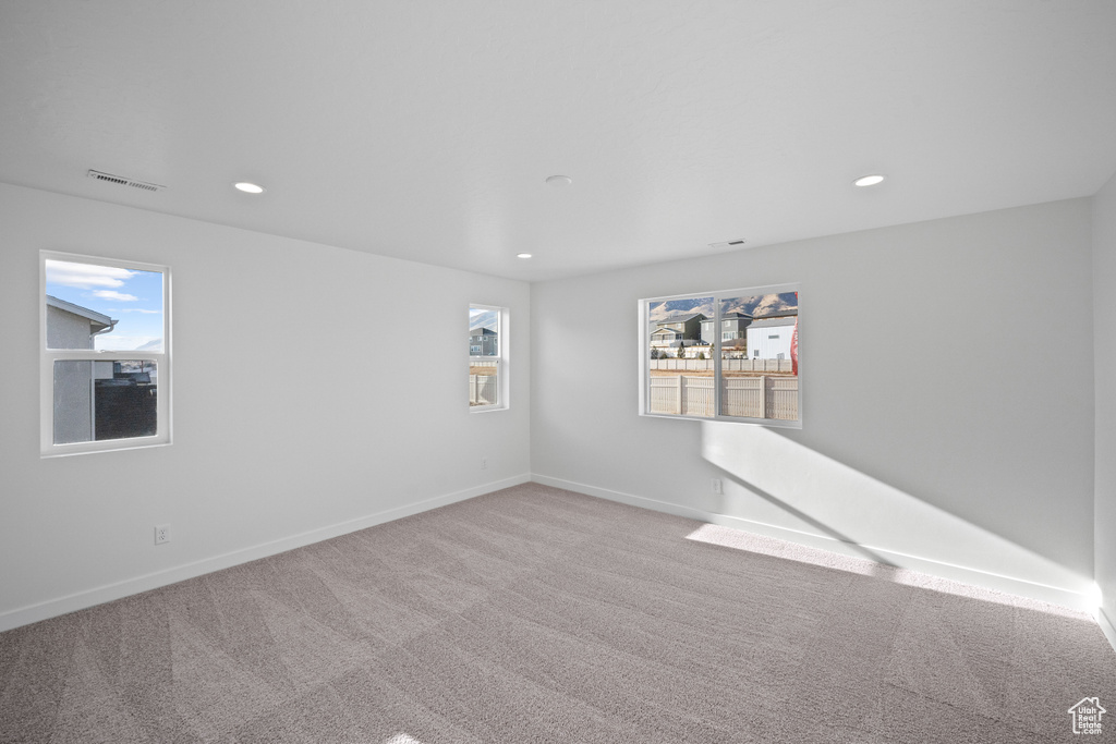 Carpeted empty room featuring recessed lighting and baseboards