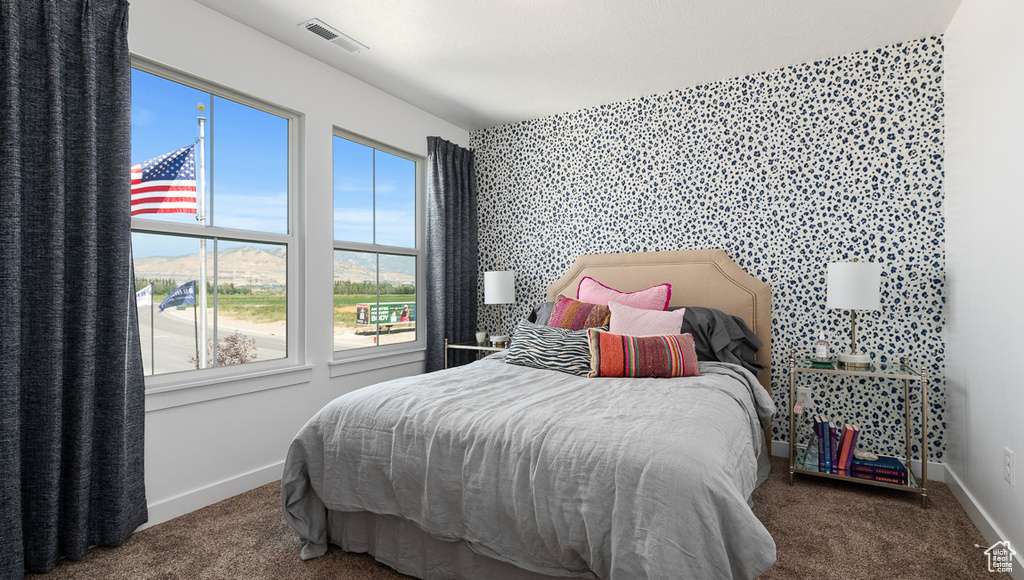 Carpeted bedroom featuring baseboards and wallpapered walls