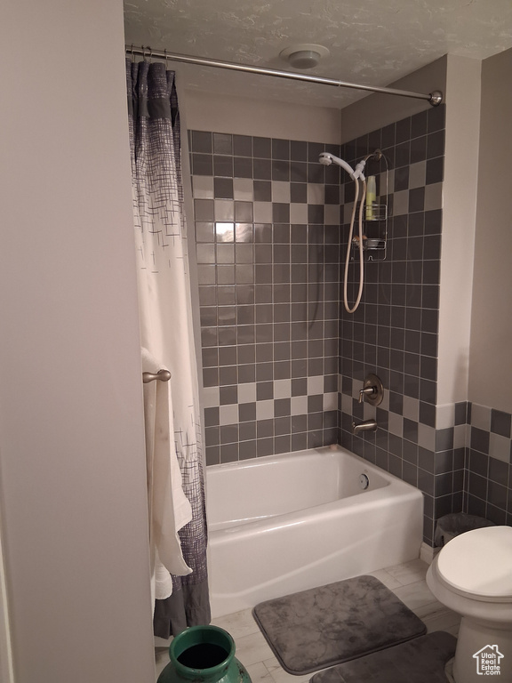 Full bath featuring shower / bath combo and toilet