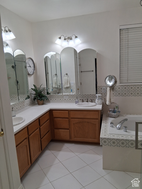 Full bath featuring double vanity, a bath, and tile patterned floors