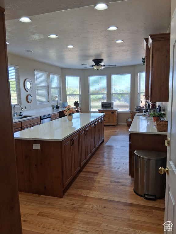 Kitchen featuring light wood-style flooring, a sink, recessed lighting, and light countertops