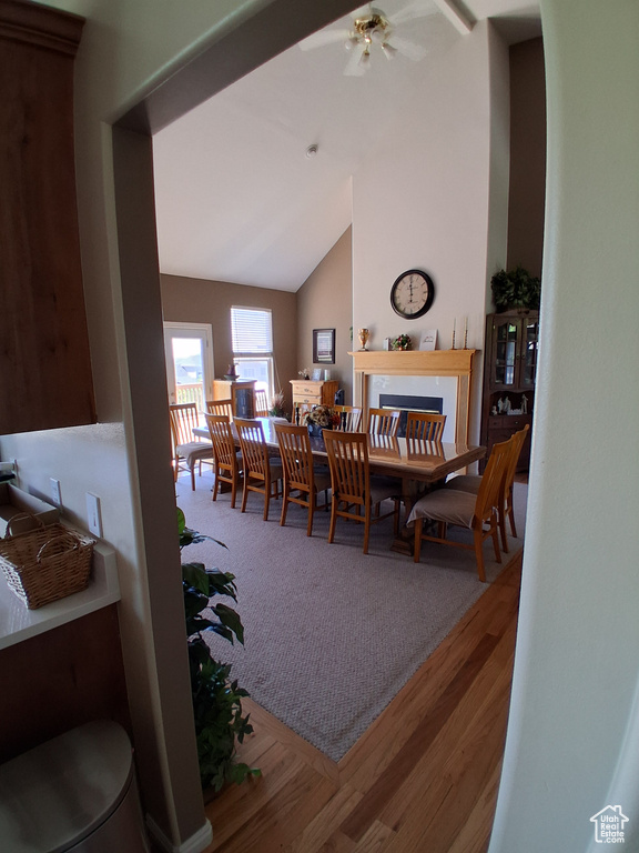 Dining room with vaulted ceiling, a ceiling fan, and wood finished floors