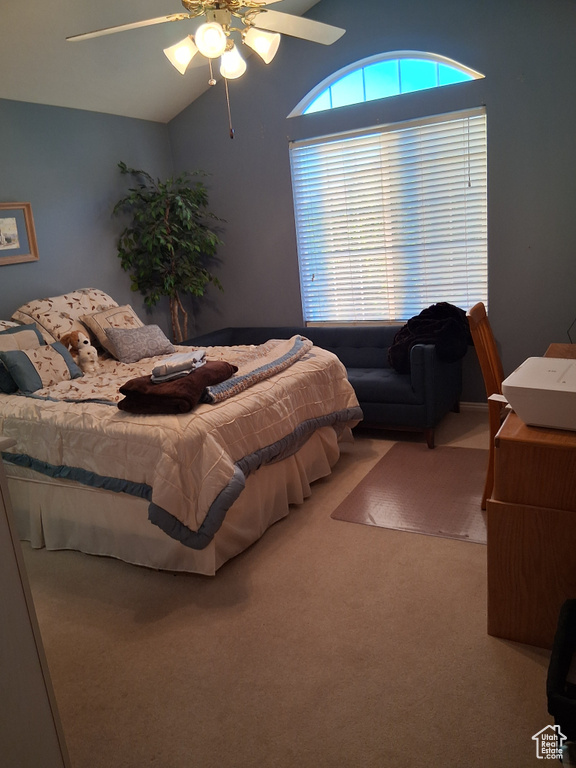 Carpeted bedroom featuring lofted ceiling and a ceiling fan