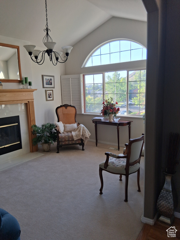 Sitting room with lofted ceiling, a fireplace with flush hearth, a chandelier, and carpet flooring