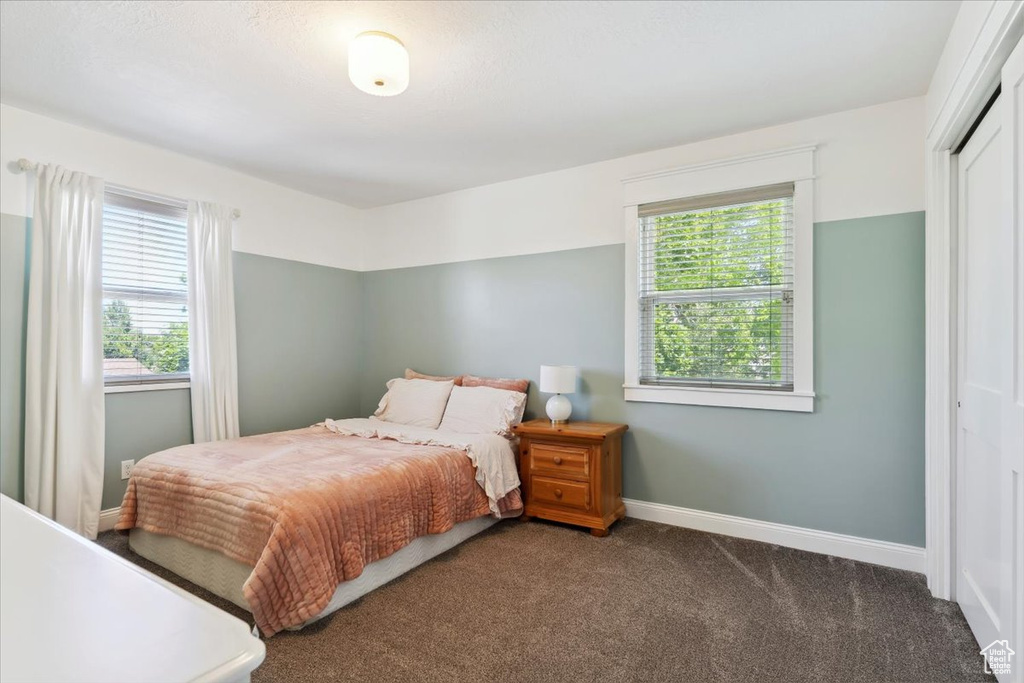 Bedroom with carpet flooring, baseboards, and a closet