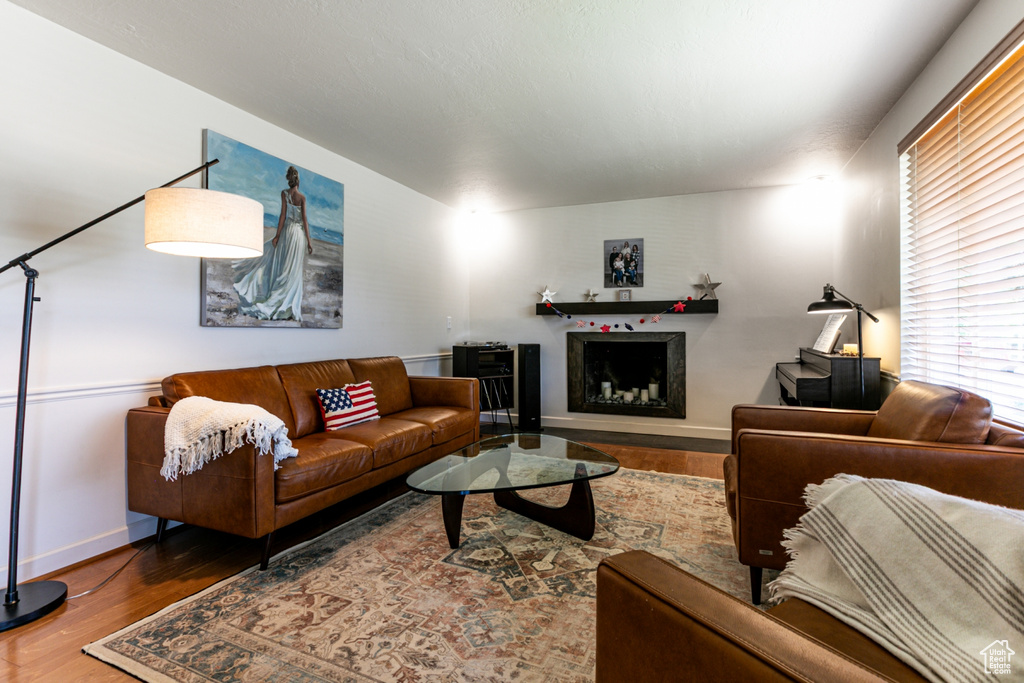 Living room with wood finished floors, baseboards, and a fireplace