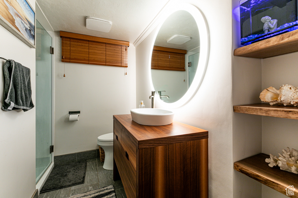 Bathroom with vanity, toilet, a shower stall, and baseboards