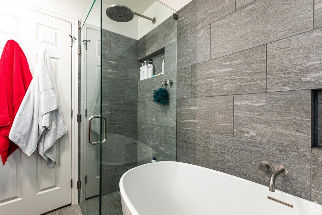 Bathroom featuring a stall shower and a freestanding tub