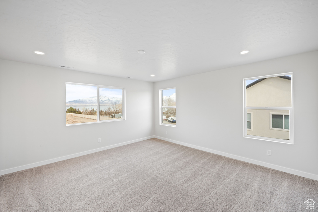 Carpeted empty room featuring baseboards and recessed lighting
