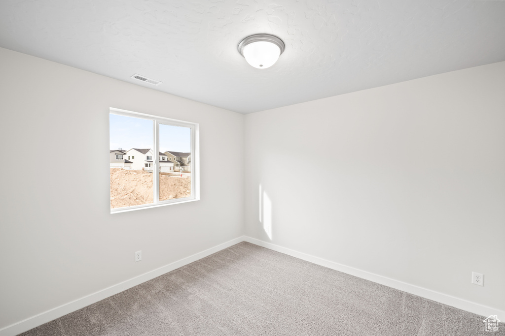 Carpeted empty room with baseboards