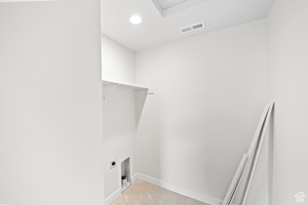Washroom featuring electric dryer hookup, baseboards, light tile patterned floors, and recessed lighting